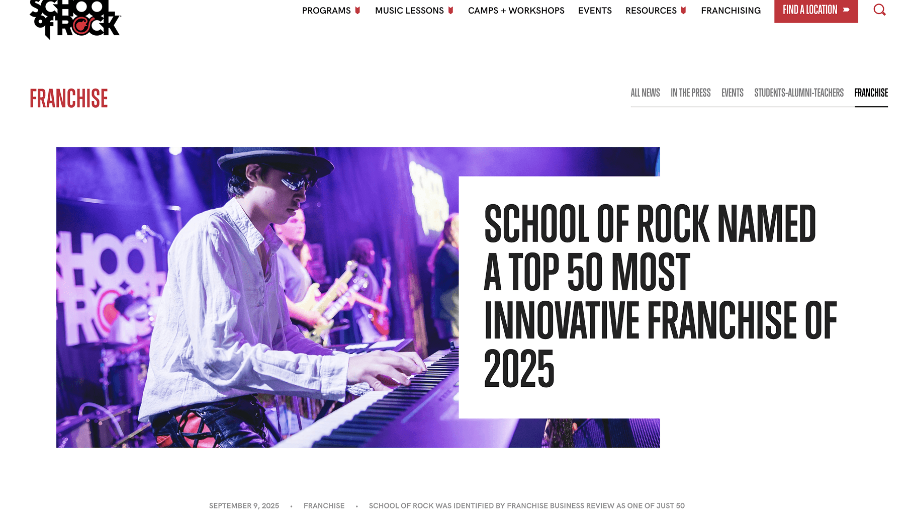 A person wearing a white shirt, hat, and sunglasses plays keyboard on a lit stage, with band members and a School of Rock banner in background.