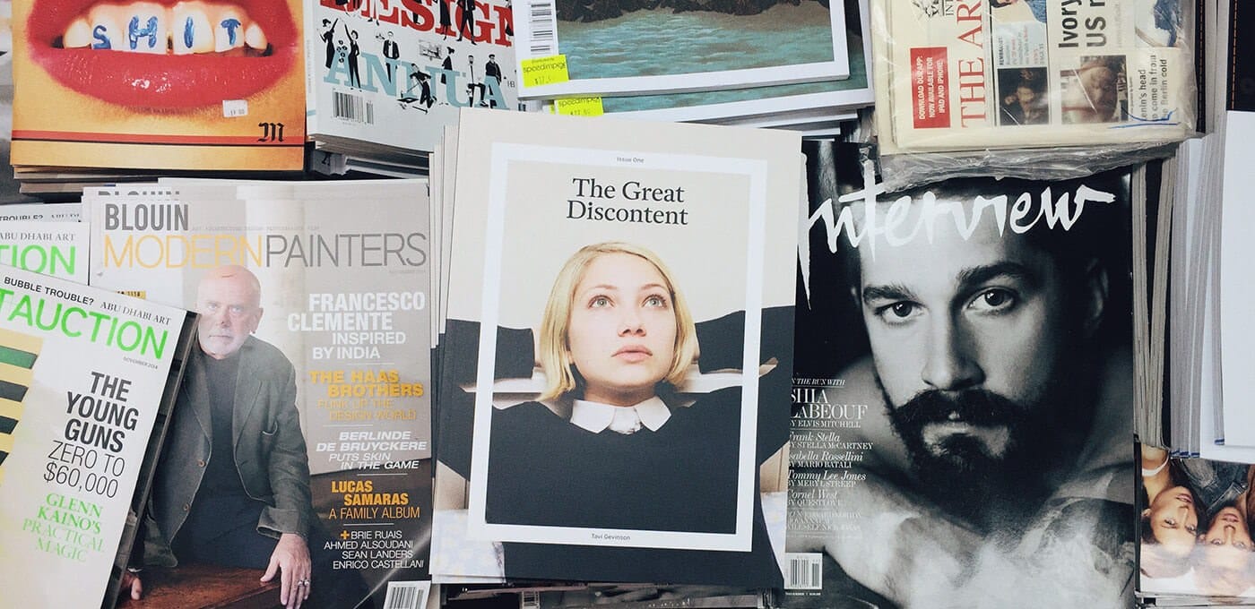 Stack of art magazines; center cover reads The Great Discontent showing a blonde person; right features a black-and-white Interview portrait; left shows Young Guns and Modern Painters issues.