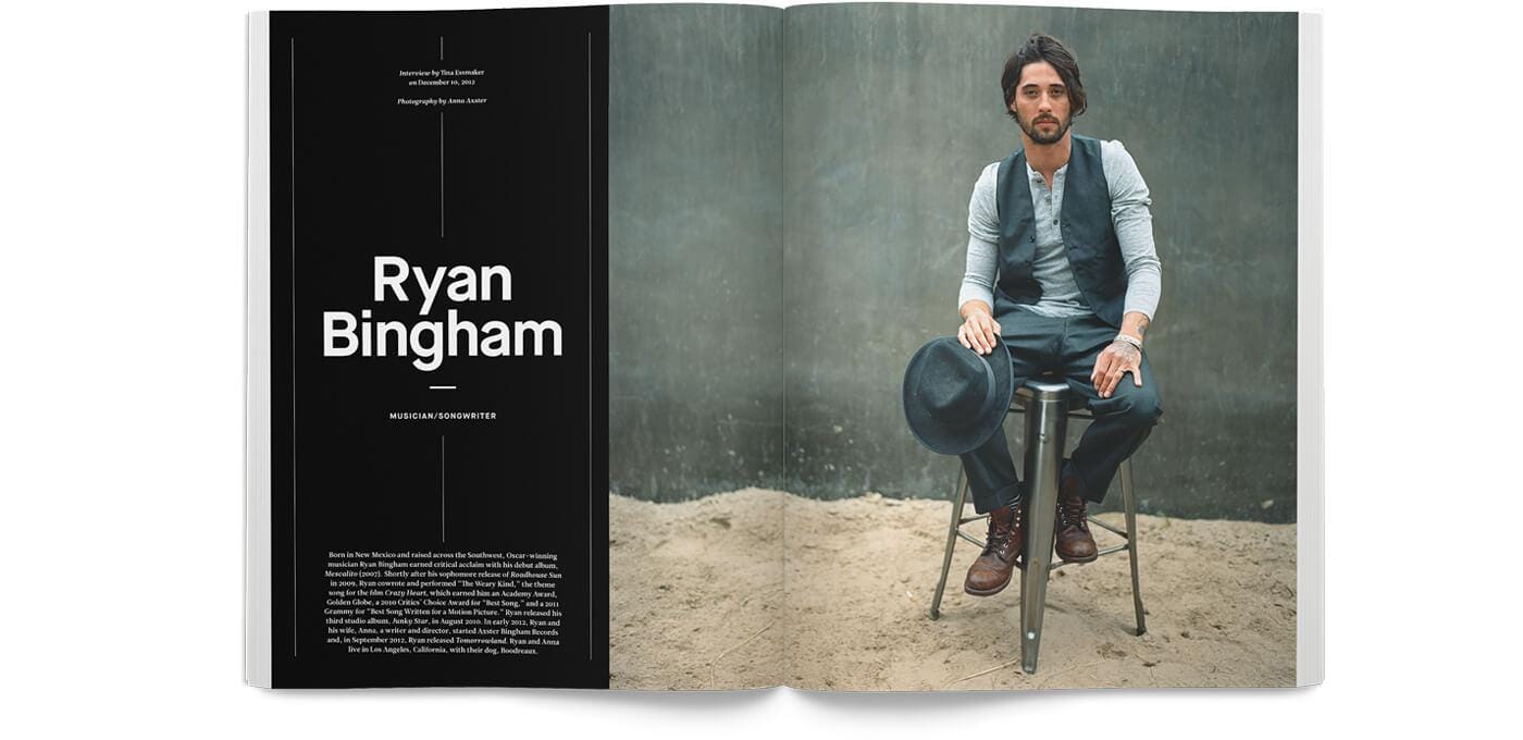 Open magazine spread; left black page with large white Ryan Bingham text, right page shows a casually dressed person on a metal stool near gray wall.