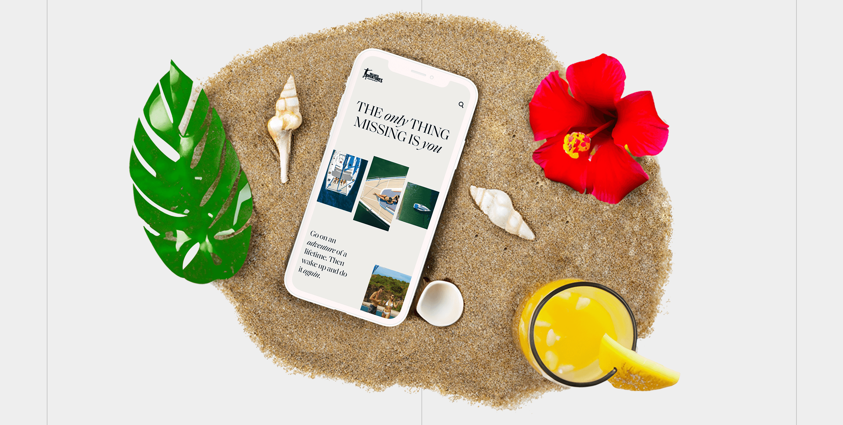 Smartphone on a sandy circle among tropical props—monstera leaf, hibiscus, shells, and juice; screen shows a magazine-style headline layout.