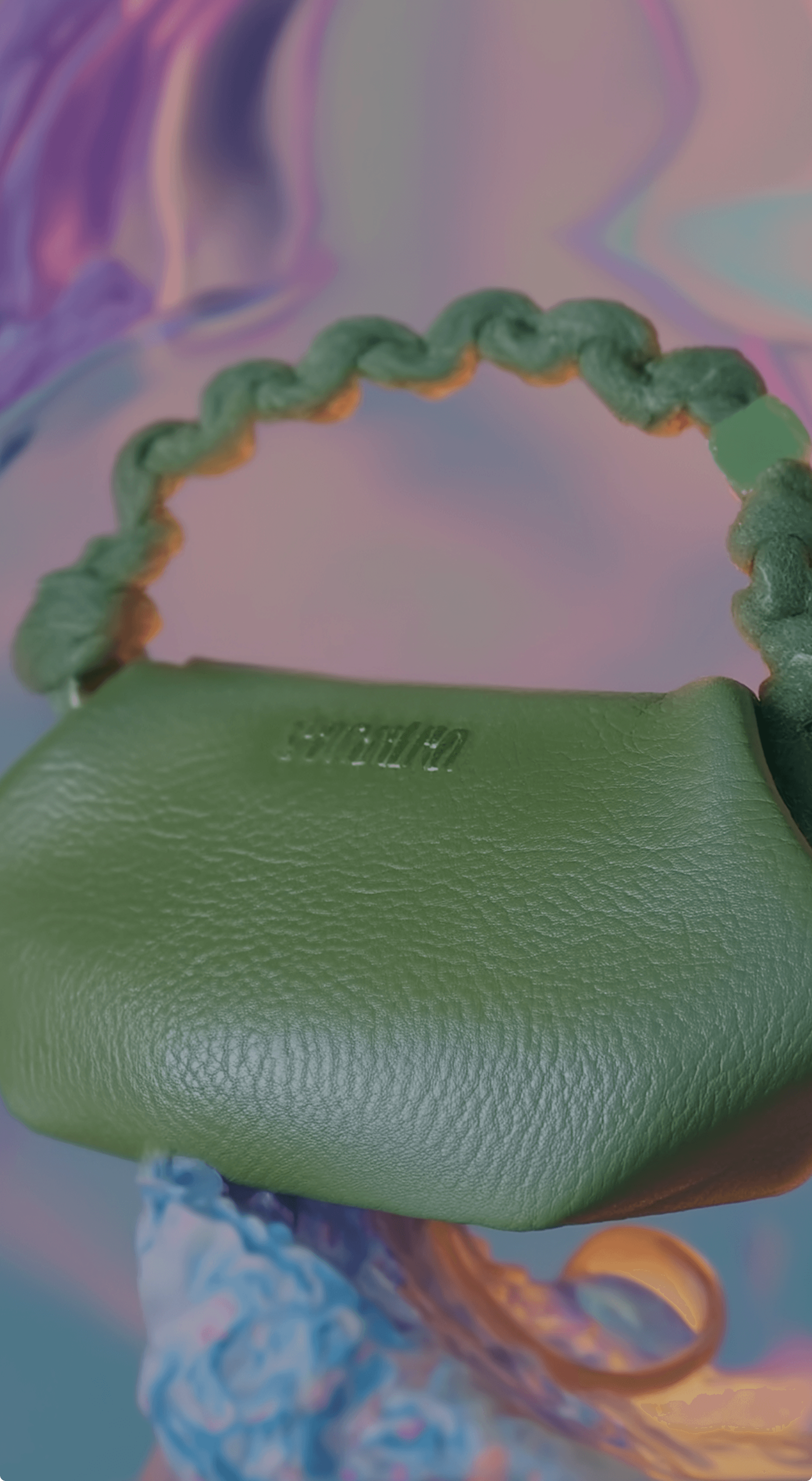 Close-up of a lime green textured leather pouch with a braided green-yellow strap and embossed logo, set against a soft pastel iridescent backdrop.